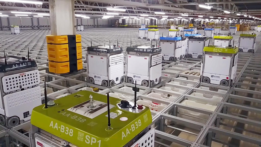 Ocado Smart Platform showing autonomous robots operating across a grid system for warehouse automation.